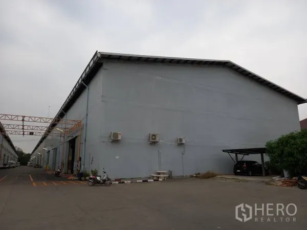 仓库 for rent in Mueang Pathum Thani, Pathum Thani - 仓库外立面带壁挂空调与带顶停车位。