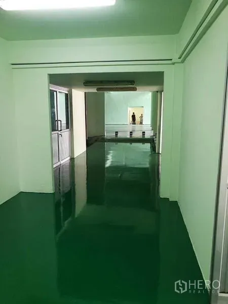 工厂 出租在Mueang Samut Sakhon, Samut Sakhon - 内部长走道通往生产区，环氧地坪与条形灯。