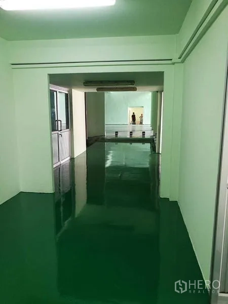 工厂 出租在Mueang Samut Sakhon, Samut Sakhon - 内部长走道通往生产区，环氧地坪与条形灯。