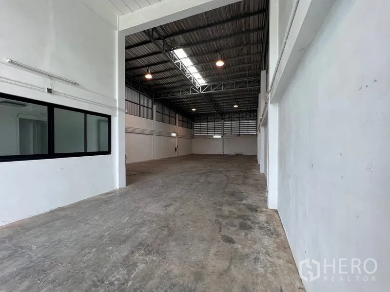 Warehouse for rent in Bang Phli, Samut Prakan - High-clearance warehouse hall with steel truss roof, skylight and concrete floor.