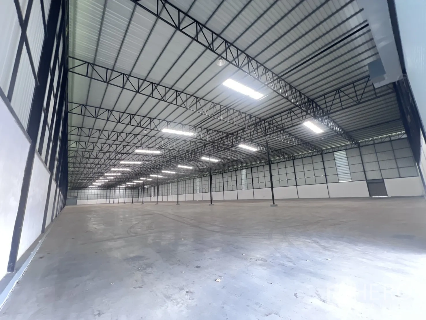 仓库 for rent in Mueang Samut Sakhon, Samut Sakhon - 内部宽景，展示柱网、照明与侧墙通风口。
