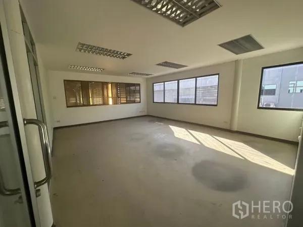 Warehouse for rent in Saphan Sung, Bangkok - Bright office room with multiple windows and fluorescent lighting.