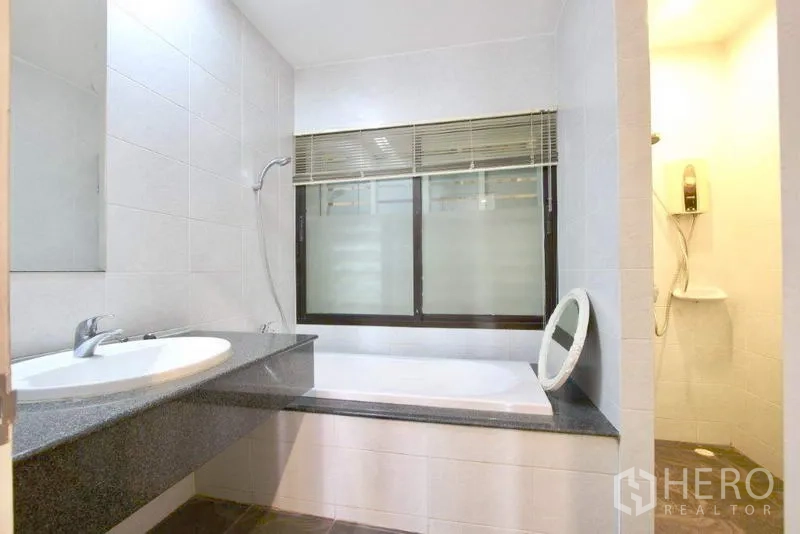 Townhouse for sale in Suan Luang, Bangkok - Bathroom with bathtub, separate shower, and granite counter sink.