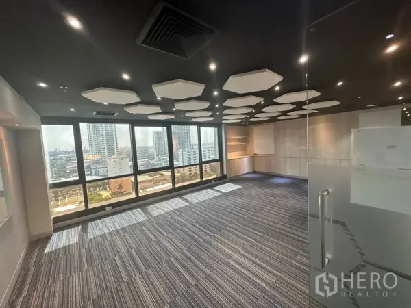 Office Space for rent in Khlong Toei, Bangkok - Meeting room with hexagonal acoustic panels, striped carpet and skyline view.
