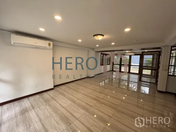 Detached House for rent in Watthana, Bangkok - Bright living room with shiny floor tiles, recessed lights and large windows.