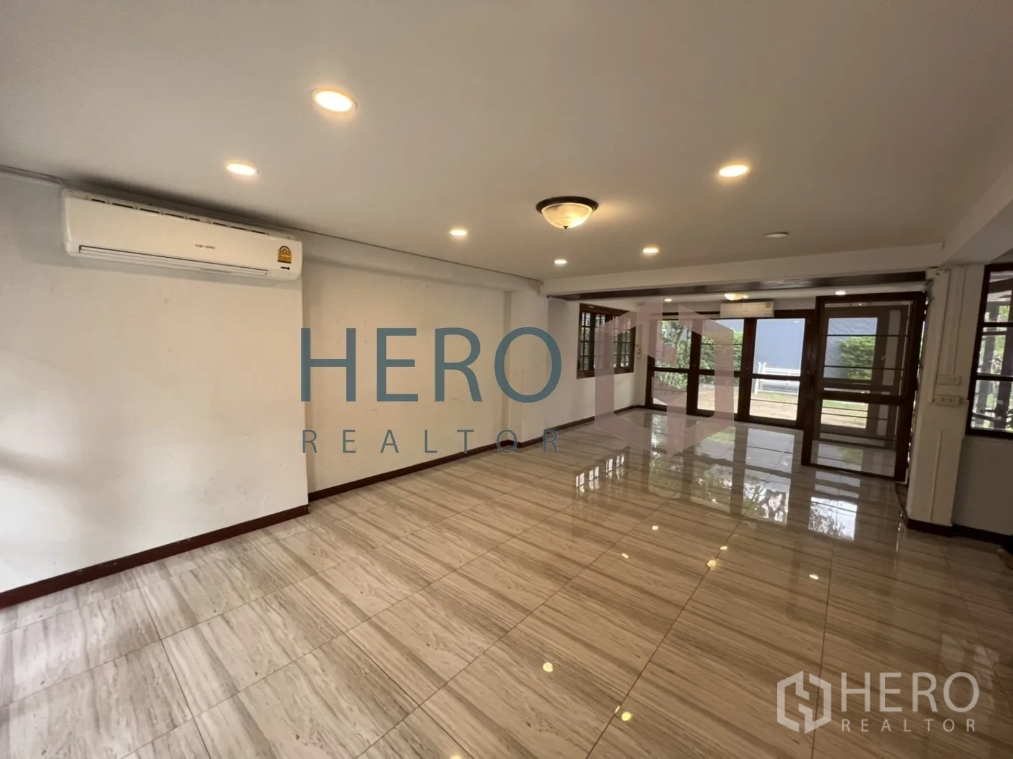 Detached House for rent in Watthana, Bangkok - Bright living room with shiny floor tiles, recessed lights and large windows.