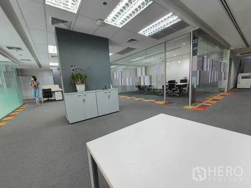 Office Space for rent in Ratchathewi, Bangkok - Open-plan workspace with grey carpet, storage cabinet, and glass-walled meeting rooms.
