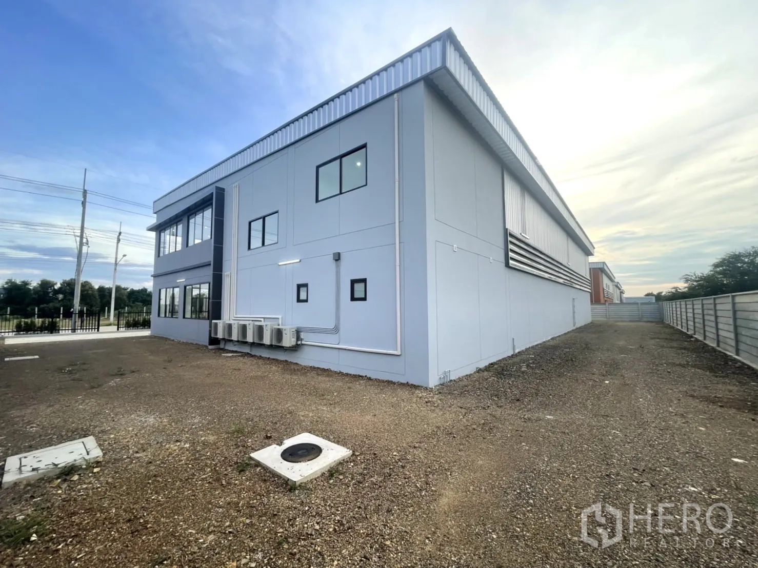 Factory for rent or sale in Bang Yai, Nonthaburi - Gravel side yard running along the building and boundary fence.