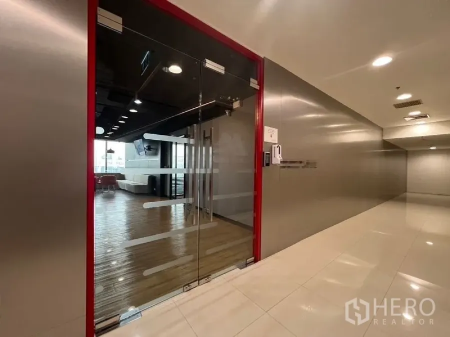 Office Space for rent in Huai Khwang, Bangkok - Glass access door with keycard system opening to a lobby with seating.