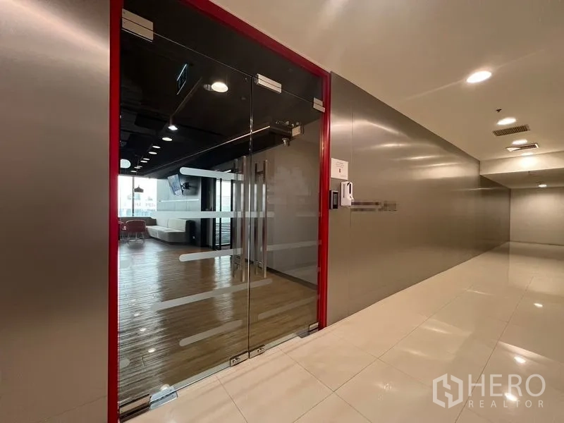 Office Space for rent in Huai Khwang, Bangkok - Glass access door with keycard system opening to a lobby with seating.