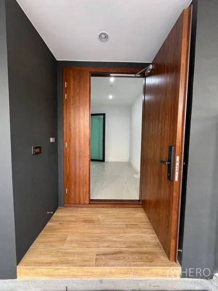 Townhouse for rent - Solid wood pivot front door with smart lock and tiled entry step.