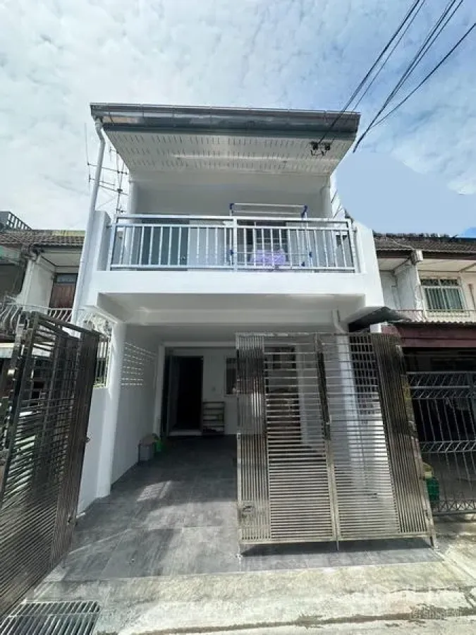 Townhouse for rent in Phra Khanong, Bangkok - Front exterior of the refreshed townhouse with balcony and stainless sliding gates.