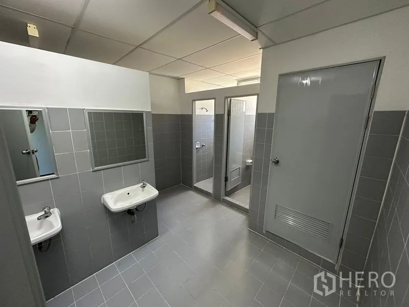 Factory for rent in Bang Bo, Samut Prakan - Clean restroom block with sinks, mirrors and separate toilet stalls.