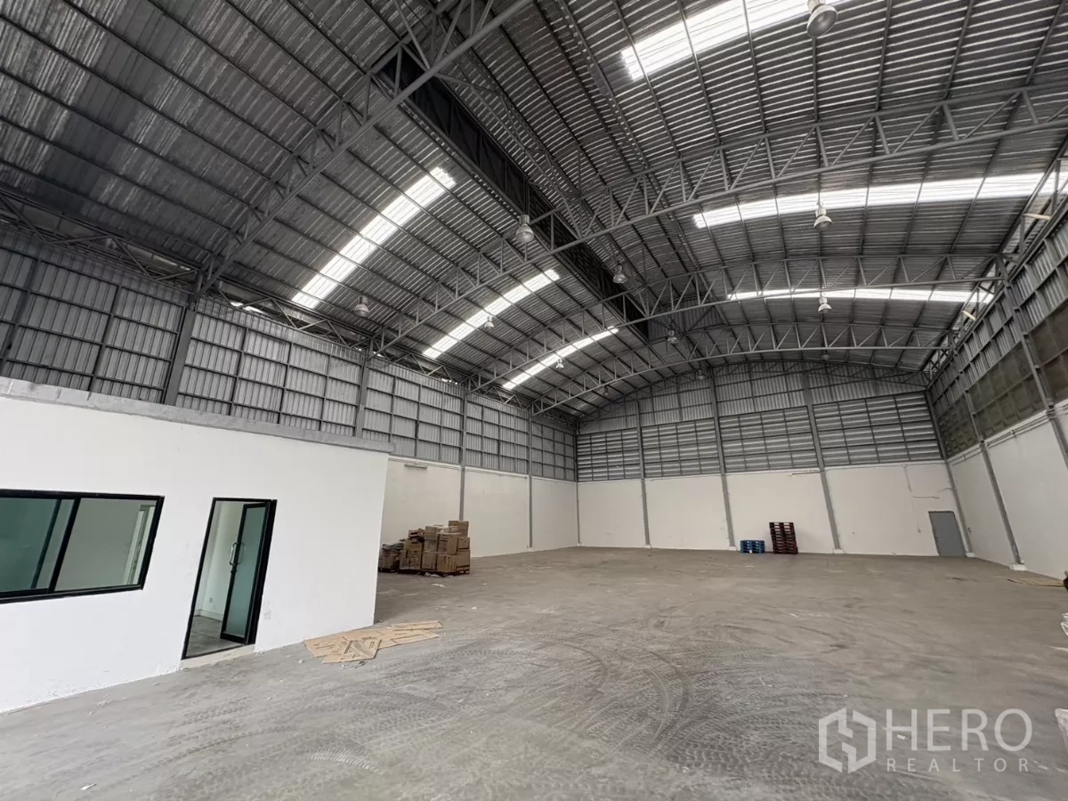 货栈 出租在Bang Phli, Samut Prakan - 仓库内的白色办公室模块与窗户，位于高挑屋顶下。