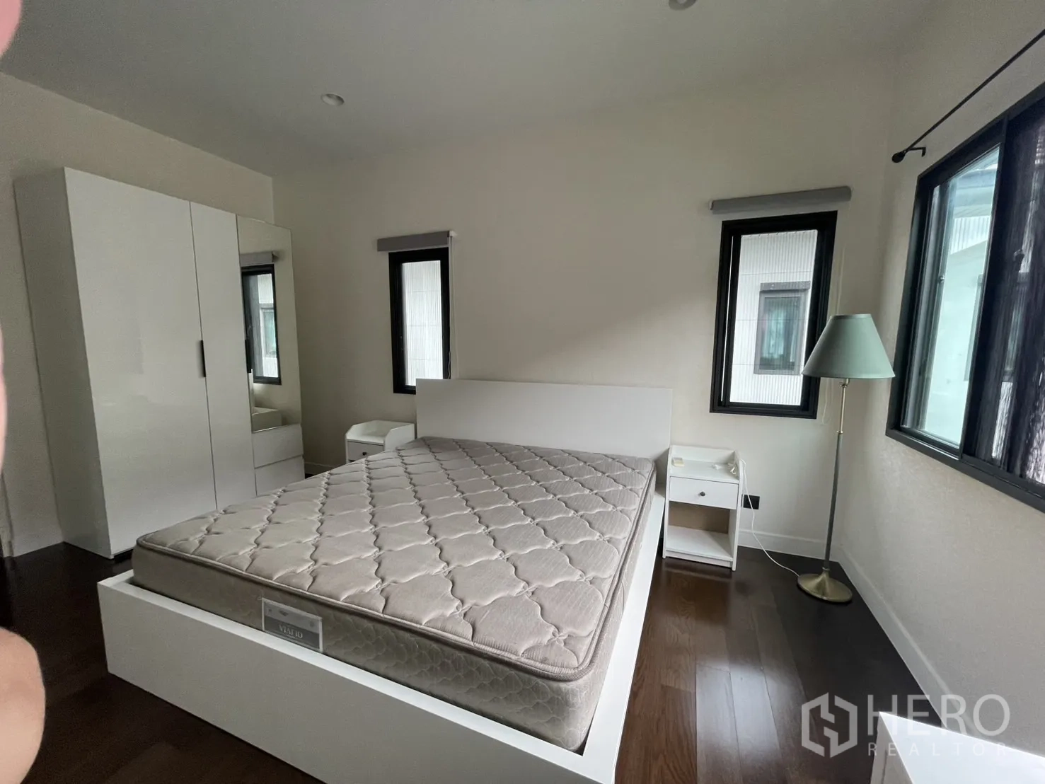 Detached House for rent in Bang Kapi, Bangkok - Bedroom showing wardrobe, side tables and dark wood flooring.