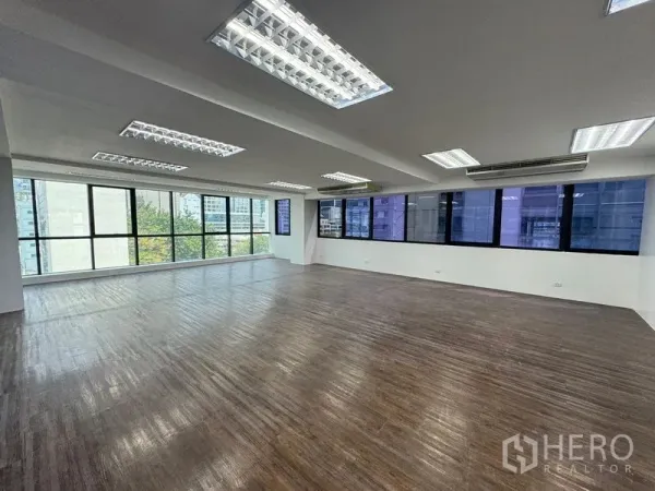 Office Space for rent in Sathon, Bangkok - Spacious unfurnished office floor with wood-style flooring and wraparound windows.