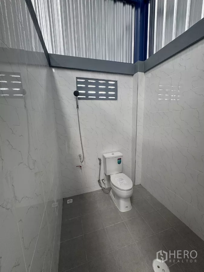 货栈 出租在Bang Phli, Samut Prakan - 仓库内干净的卫生间，瓷砖地面，坐便器与喷枪，设通风窗。