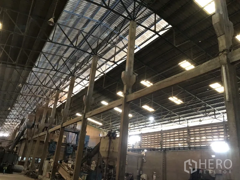 โรงงาน ให้เช่าในBang Bua Thong, Nonthaburi - มุมมองใกล้ของโครงหลังคาทรัสเหล็กและเสาพร้อมสกายไลท์