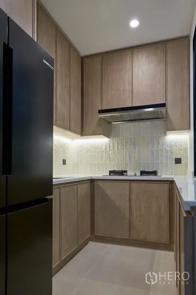 Detached House for rent in Watthana, Bangkok - Secondary kitchen with gas hobs, extractor hood and full-height cabinetry.