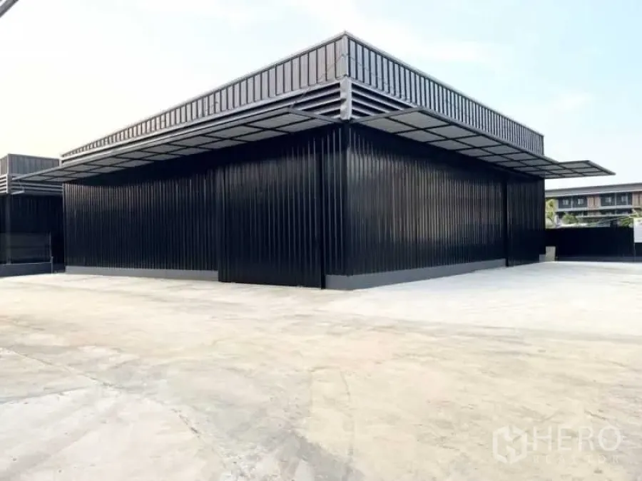 货栈 出租在Wang Thonglang, Bangkok - 金属板外墙仓库正面，环绕式遮阳雨棚与充足停车装卸区。