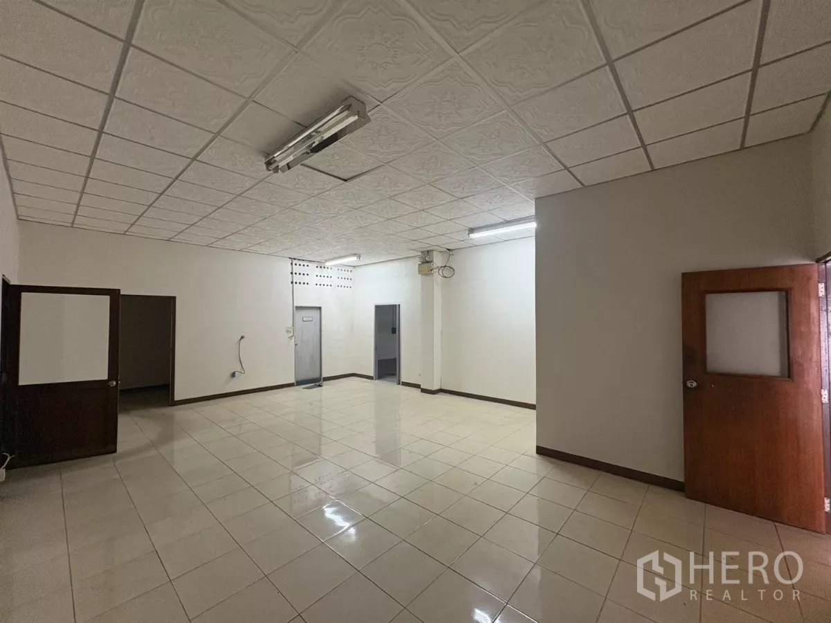 Warehouse for rent in Bang Phli, Samut Prakan - Another view of bright tiled office with multiple doors and ceiling lights.