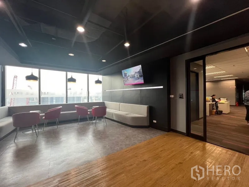 Office Space for rent in Huai Khwang, Bangkok - Breakout lounge by full-height windows with sofas, armchairs and pendant lights.