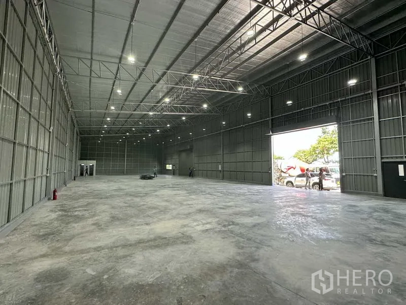 Warehouse for rent in Pak Kret, Nonthaburi - Warehouse hall with bright LED lighting, open automatic roller door and truck access from the yard.