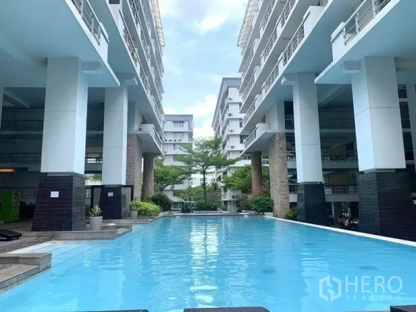 Condominium for rent in Khlong Toei, Bangkok - Long outdoor swimming pool set between modern low‑rise condo buildings.