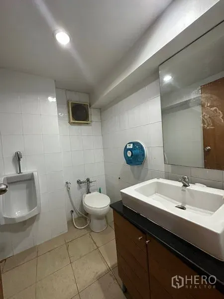 Office Space for rent in Pathum Wan, Bangkok - Clean office restroom with sink, toilet and urinal in white-tiled finish.