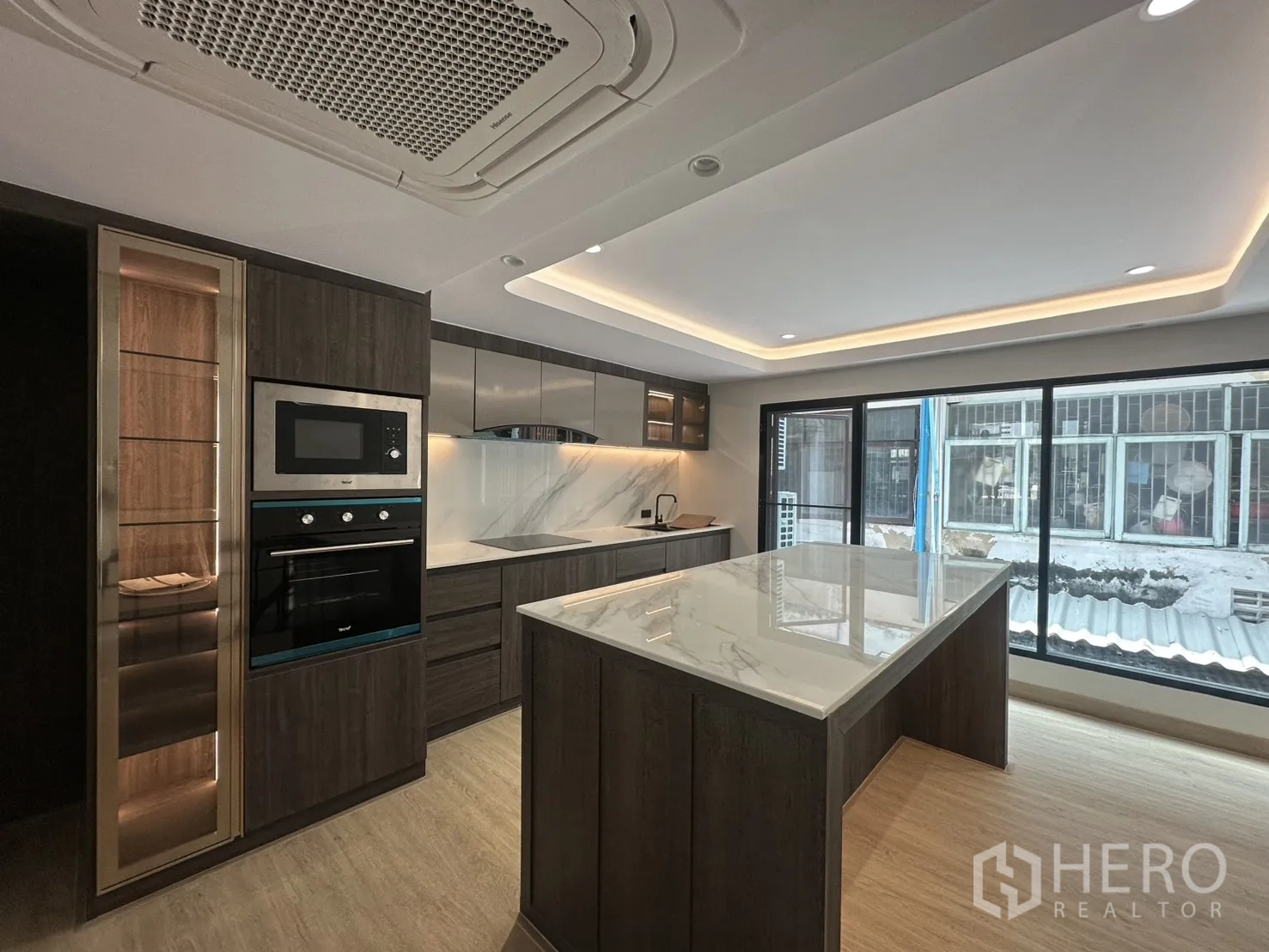 Home Office for rent in Watthana, Bangkok - Kitchen with island, built-in oven and wide windows for natural light.