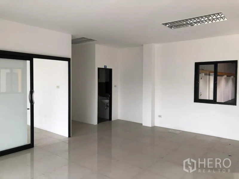 Factory for rent or sale in Bang Phli, Samut Prakan - Bright office room with tiled flooring, internal window, and sliding glass door.