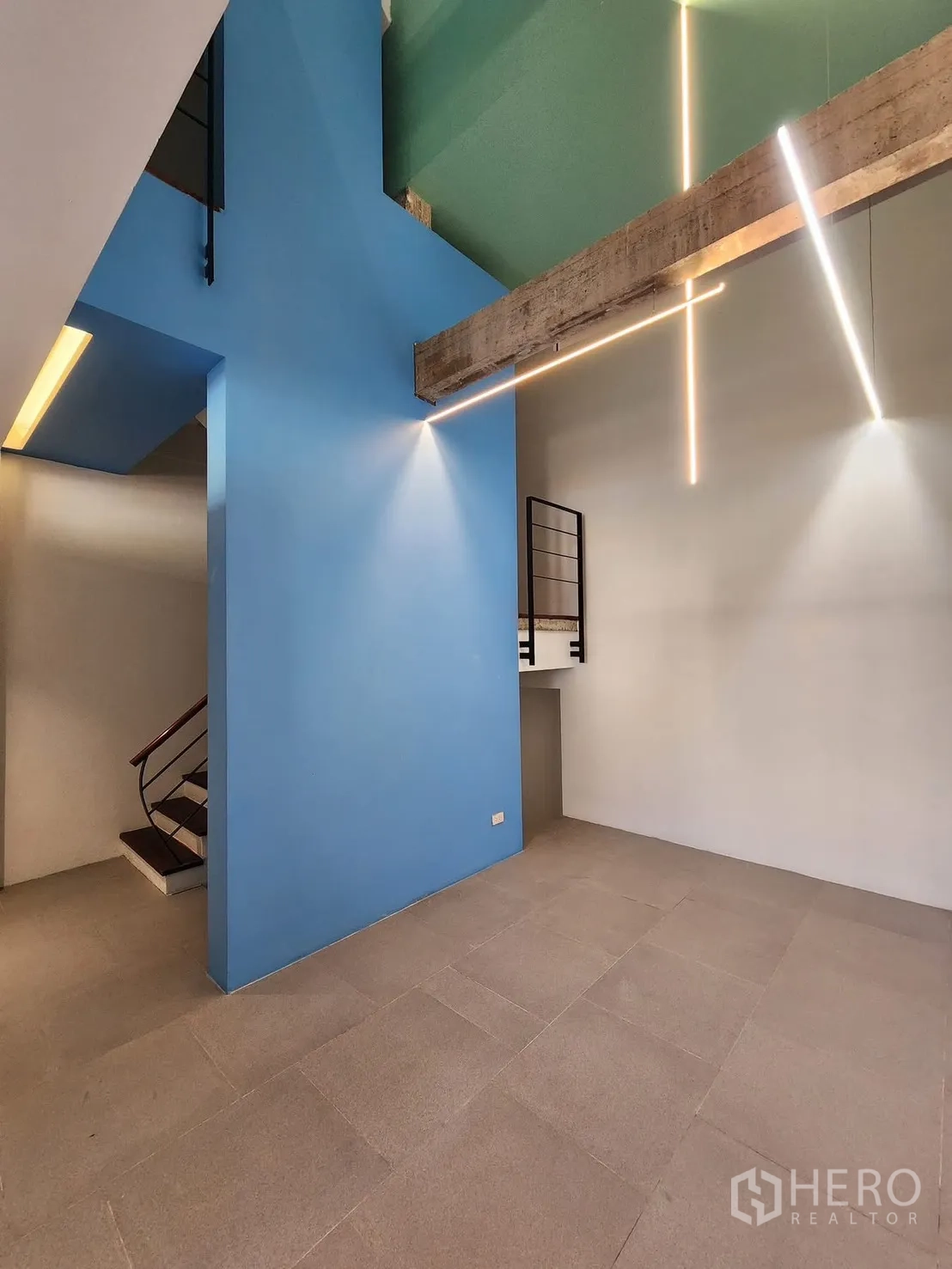 Home Office for rent in Chatuchak, Bangkok - Double-height lobby with blue wall and hanging linear lights.