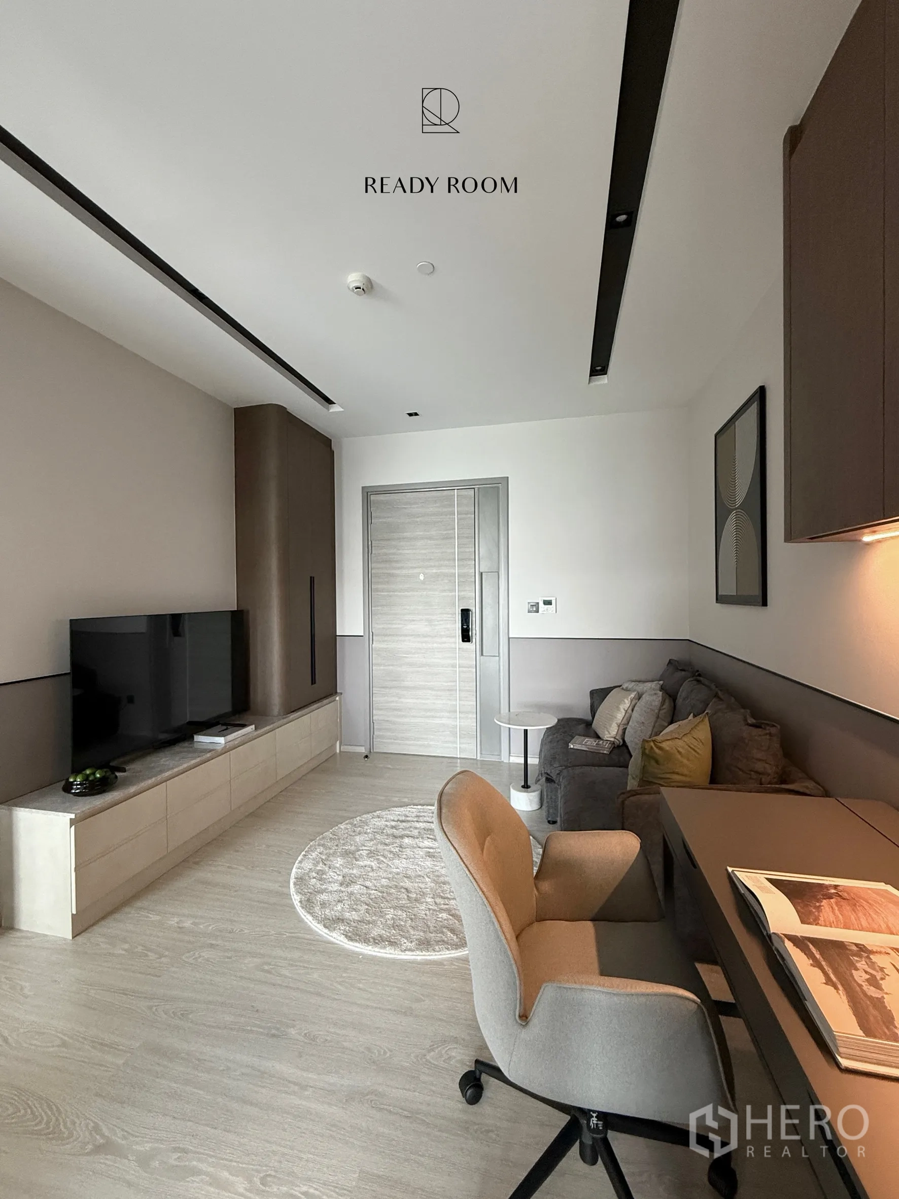 Condominium for rent in Khlong Toei, Bangkok - Modern living area with TV console, sofa, work desk, and light wood flooring.
