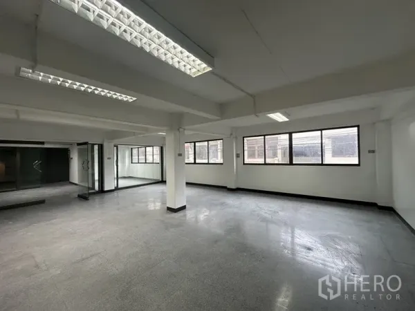 Office Space for rent in Khlong Toei, Bangkok - Bright corner workspace with multiple windows, glass partitions and grey flooring.