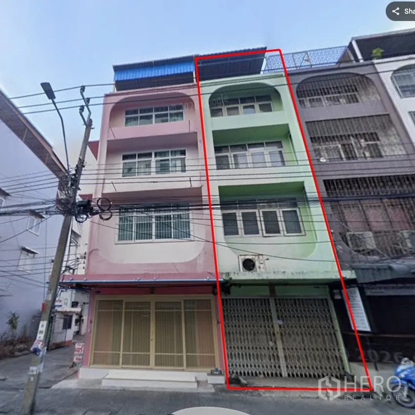 店屋 for rent in Khlong Toei, Bangkok - 四层联排商铺外立面，一层金属卷闸门与上层阳台。