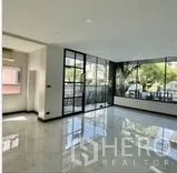 Home Office for rent in Wang Thonglang, Bangkok - Corner office area with floor-to-ceiling black-framed windows and glossy floor.