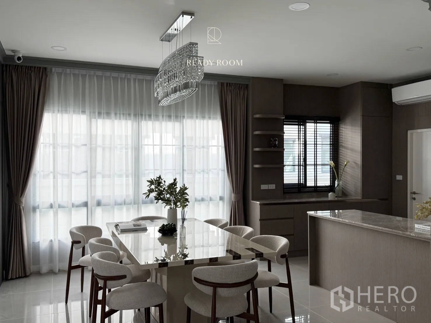Detached House for rent or sale in Bang Phli, Samut Prakan - Bright dining room with crystal chandelier, marble table and upholstered chairs beside a sleek open kitchen in a Bang Phli detached house.