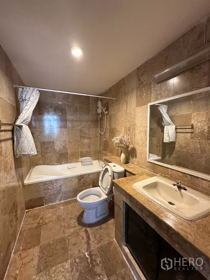 Home Office for rent in Suan Luang, Bangkok - Marble-tiled bathroom with bathtub and wide vanity.