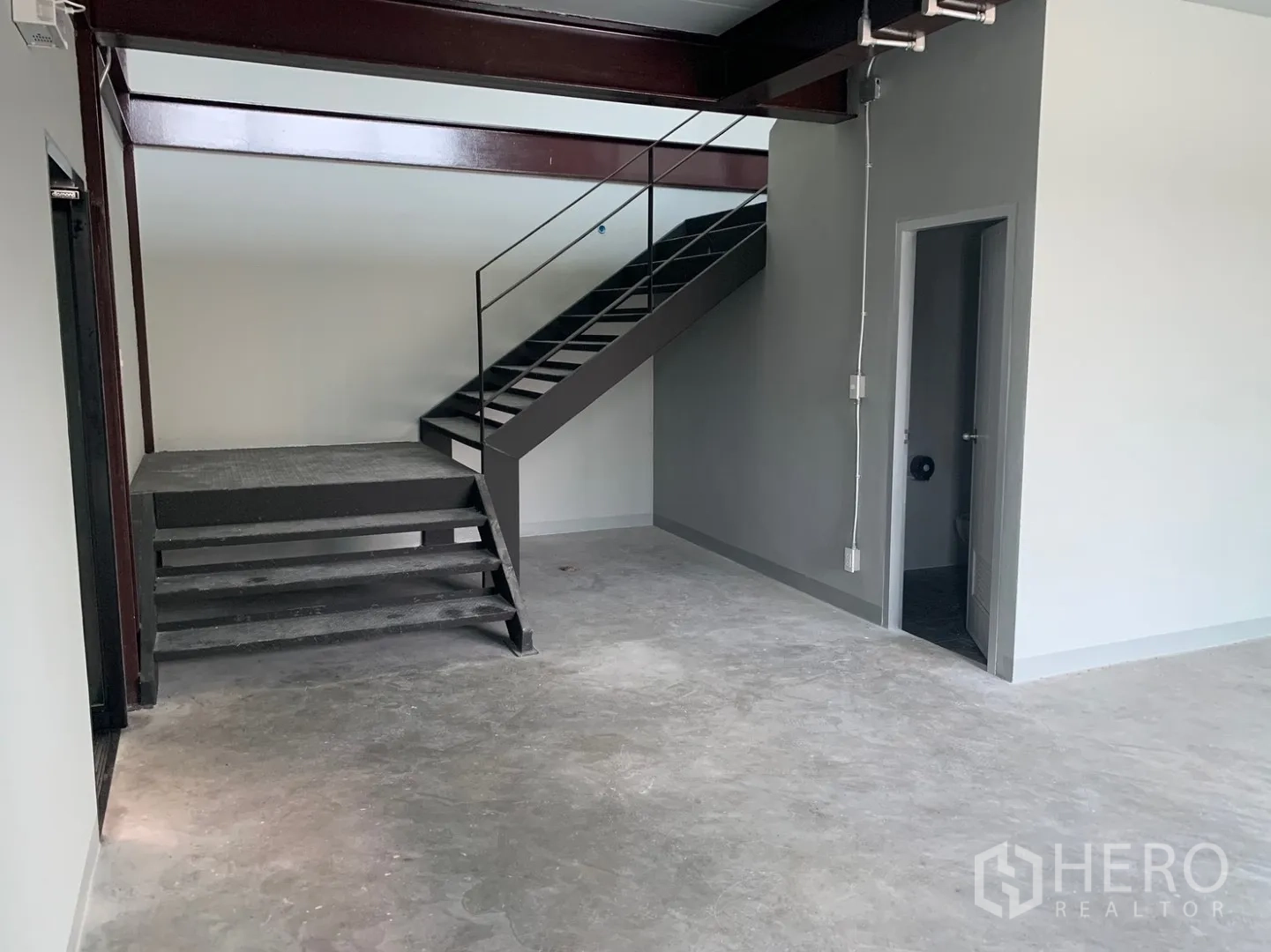仓库 for rent in Bang Phli, Samut Prakan - 一层室内设钢制楼梯、混凝土地面与卫生间门。