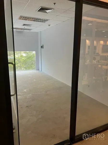 Retail Space for rent in Bang Rak, Bangkok - View through a glass door into a compact retail space with a natural-light picture window and ceiling air vents.