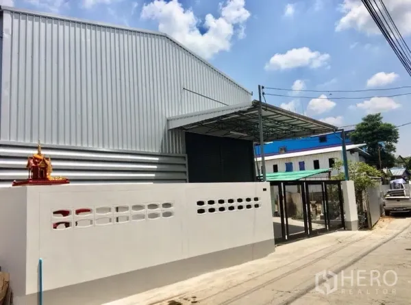 货栈 出租在Din Daeng, Bangkok - 街景视角的仓库外立面，黑色滑动大门与围墙