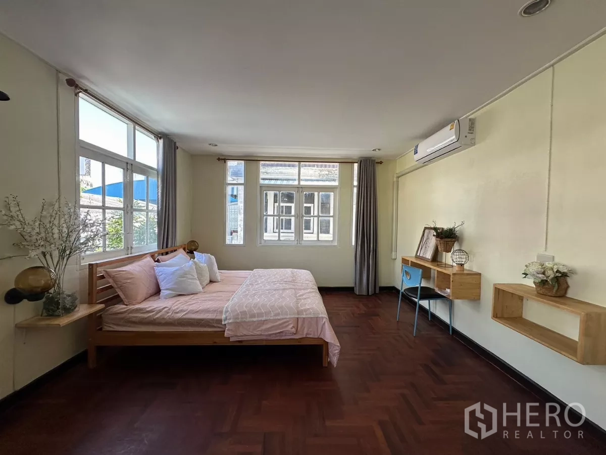 Home Office for rent in Suan Luang, Bangkok - Corner bedroom with large windows and pink bedding.