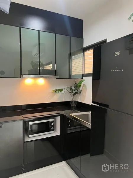 联排别墅 出租在Saphan Sung, Bangkok - 紧凑现代厨房，亮黑橱柜，内置电器与冰箱。