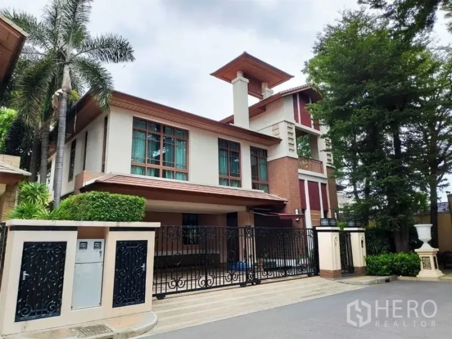 Detached House for rent in Watthana, Bangkok - Modern detached house exterior with gated carport, large windows and trees.