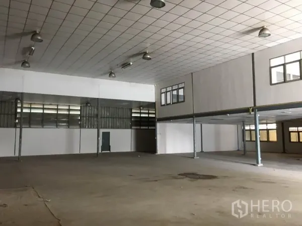 Warehouse for rent in Prawet, Bangkok - Expansive floor area with concrete slab facing the mezzanine office section and multiple access points.