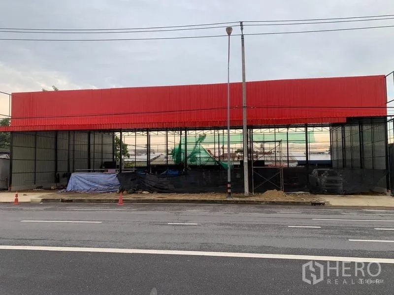Warehouse for rent in Bueng Kum, Bangkok - Front elevation of the warehouse showing the red facade, open steel structure and curbside access.