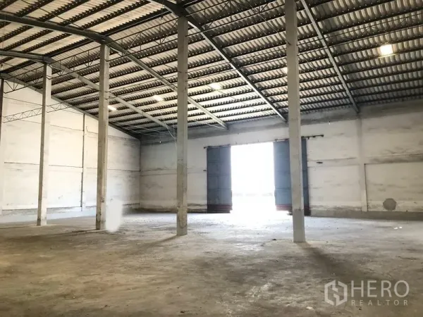 Warehouse for rent in Lat Krabang, Bangkok - Large warehouse hall with wide loading doors opening to the yard, high clearance and multiple concrete pillars.