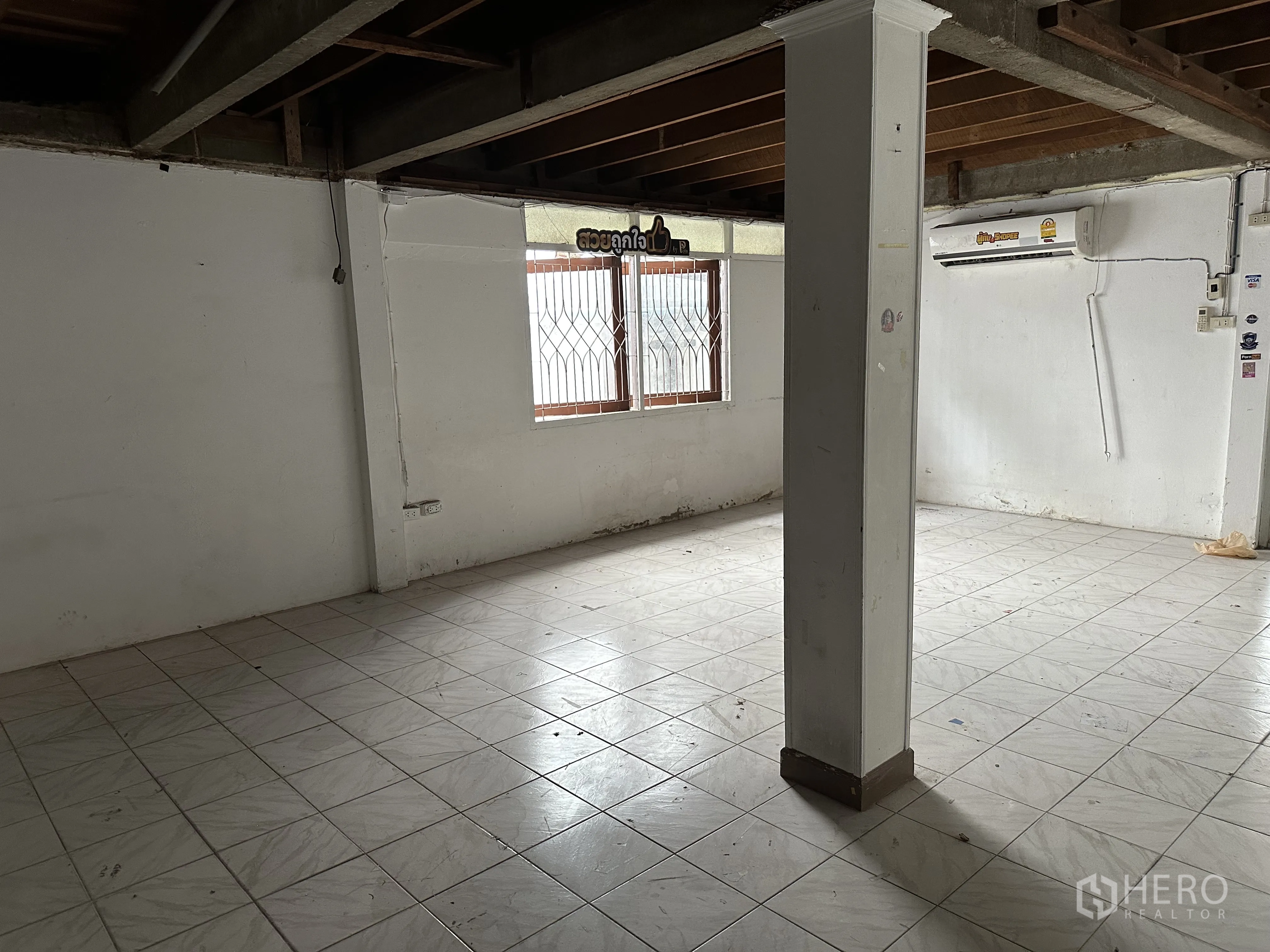 Home Office for rent in Suan Luang, Bangkok - Ground-floor open area with column, tiled floor and window with security grilles.