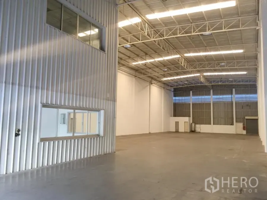 Factory for rent in Khlong Luang, Pathum Thani - Bright high-bay factory interior with steel truss roof, polished concrete floor and internal office windows in Khlong Luang.