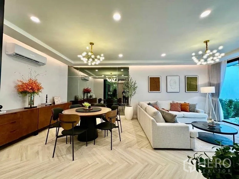 Detached House for rent in Bang Phli, Samut Prakan - Open-plan living and dining room with chandeliers and herringbone flooring.